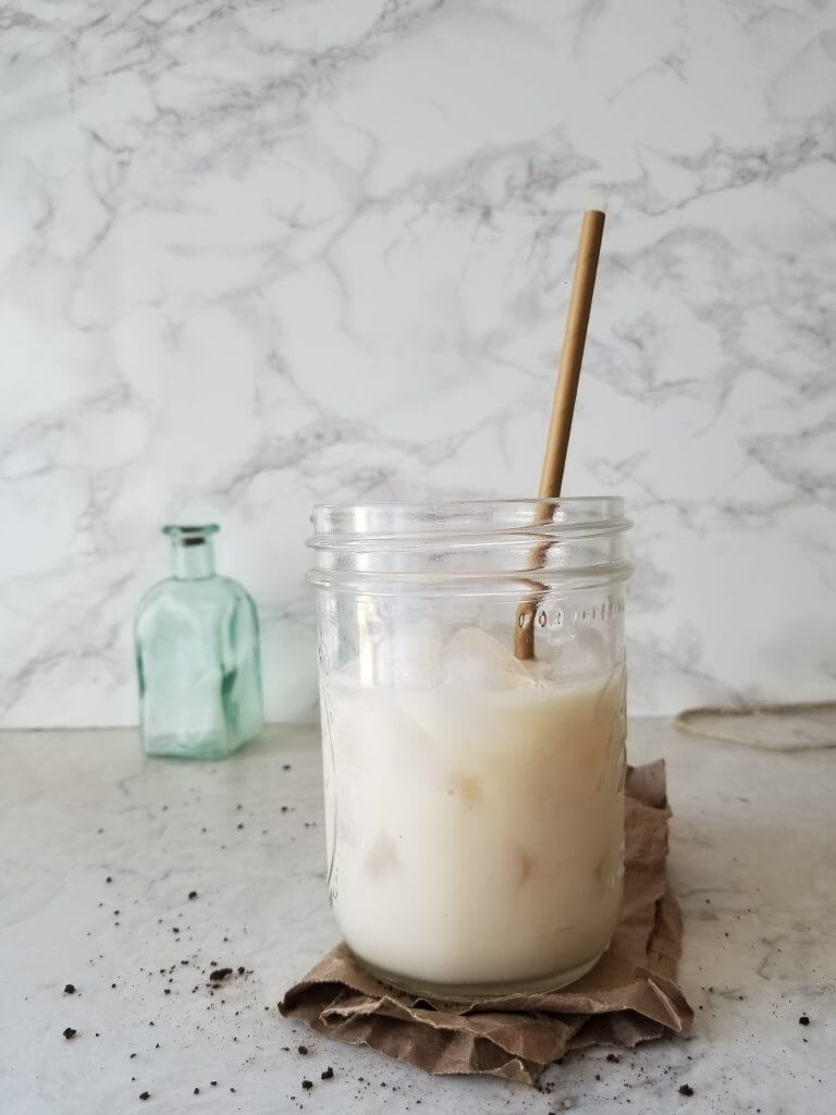 mason jar with milk and ice cubes with a white background