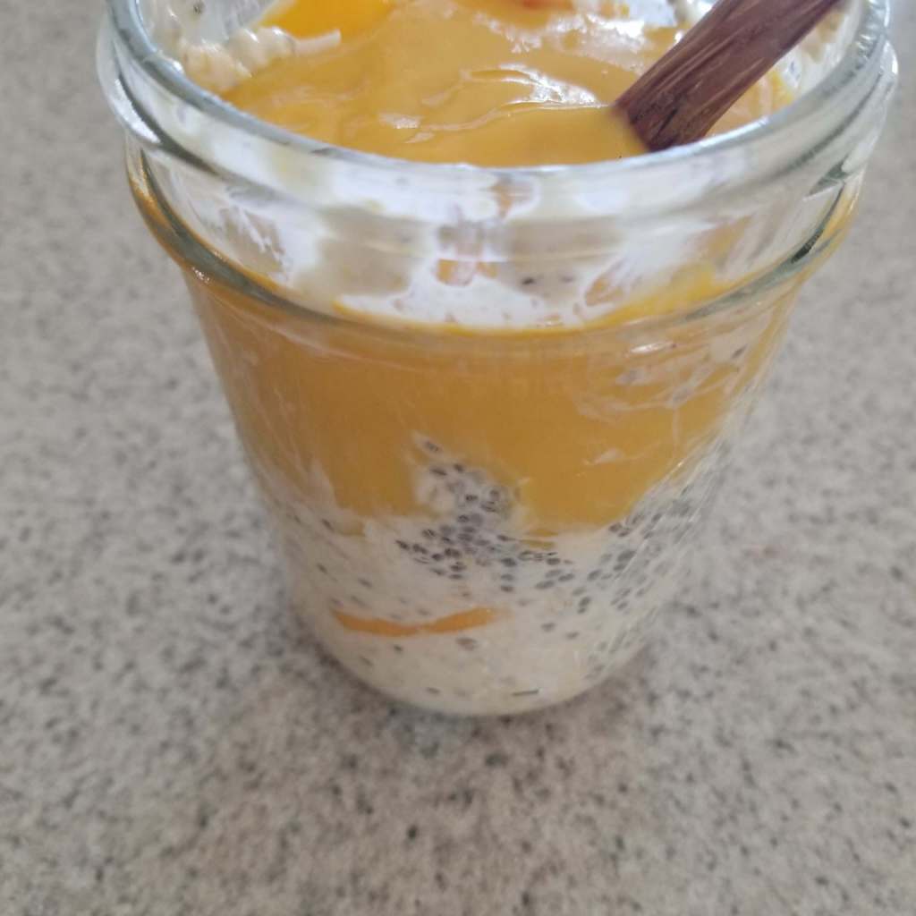 mango overnight oats with mango puree on top in a mason jar