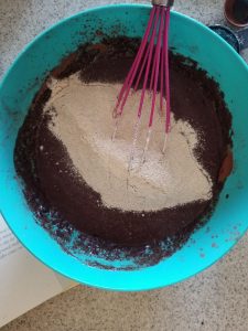 adding the dry ingredients into the wet ingredients for the dairy free banana chocolate muffins