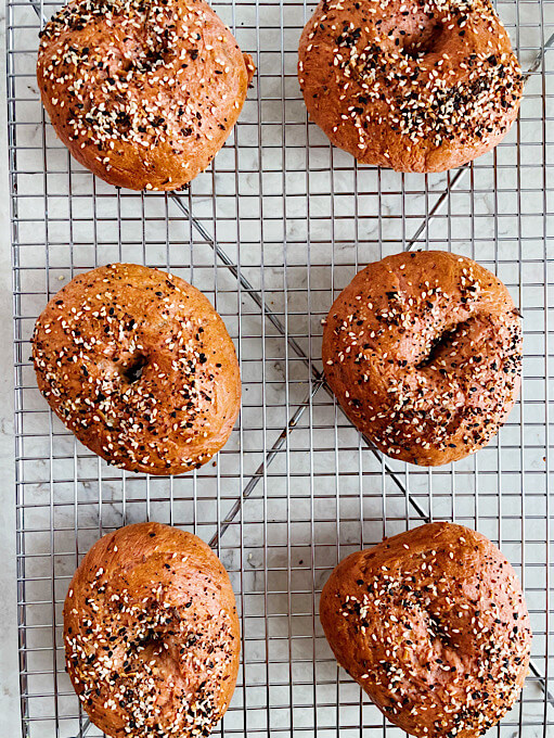 beet bagels with everything seasoning on a cooling rack