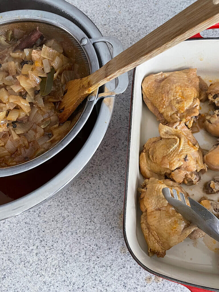 straining the kabsa broth and setting the chicken aside