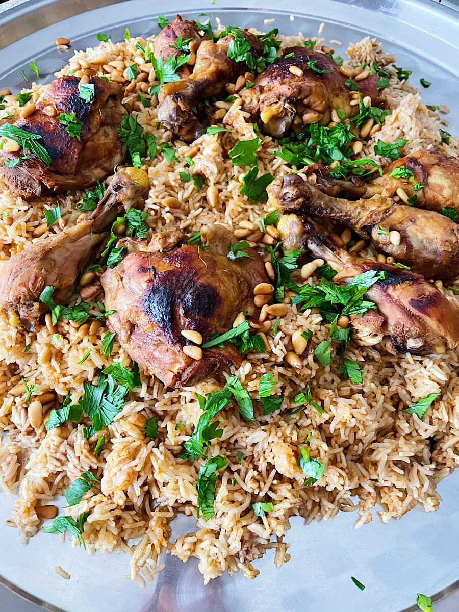 authentic chicken kabsa topped with crispy chicken, pine nuts and fresh chopped parsley