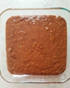 chocolate zucchini cake batter in a glass baking dish before baking