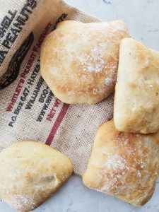ciabatta rolls on top of an old burlap bag