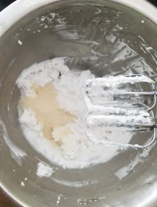 beating coconut cream in a stainless steel bowl