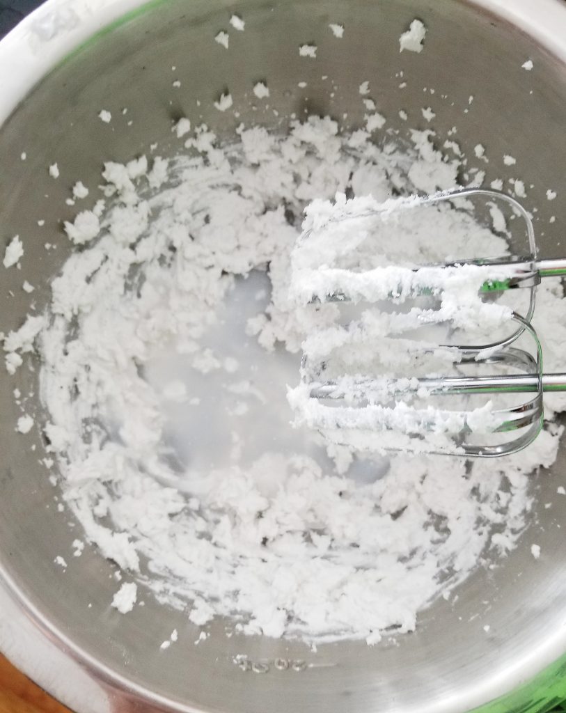 beating coconut cream in a stainless steel bowl