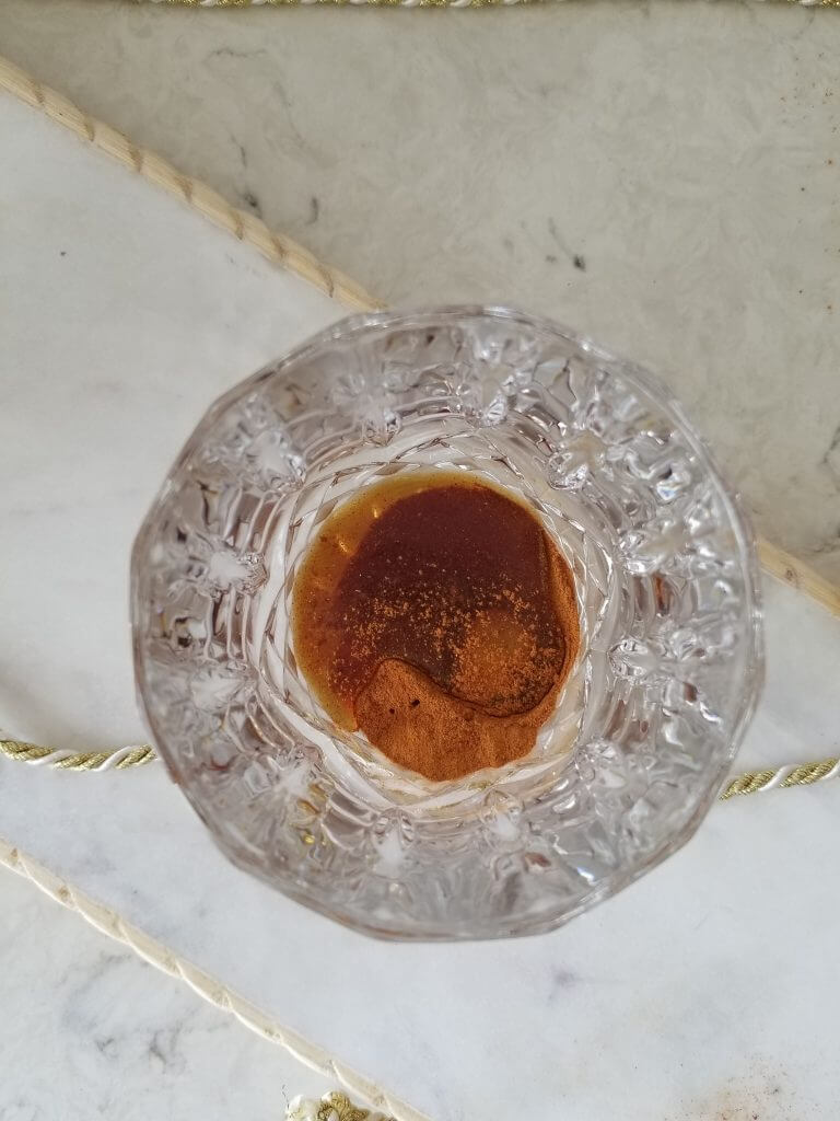 golden milk latte mix in a glass with maple syrup