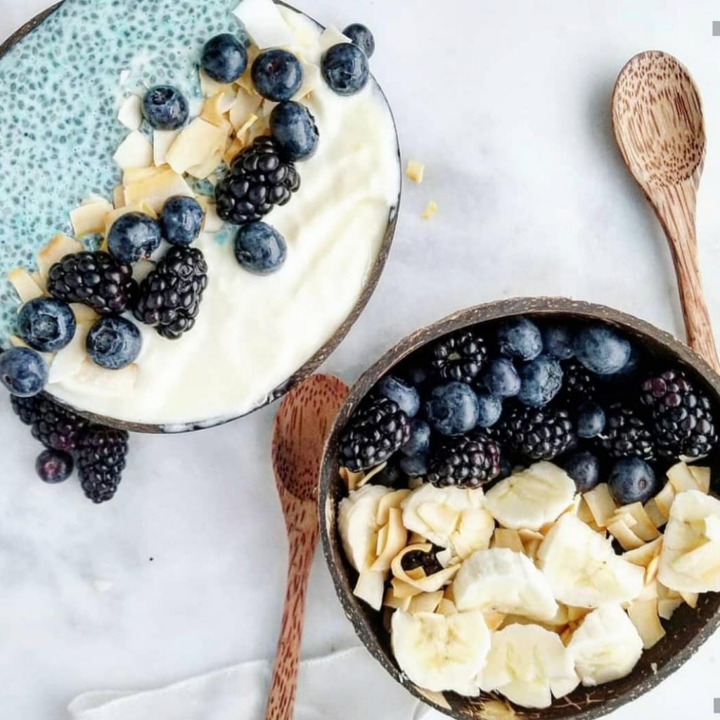 pineapple nice cream with blue chia pudding, blueberries, blackberries, bananas, and coconut chips