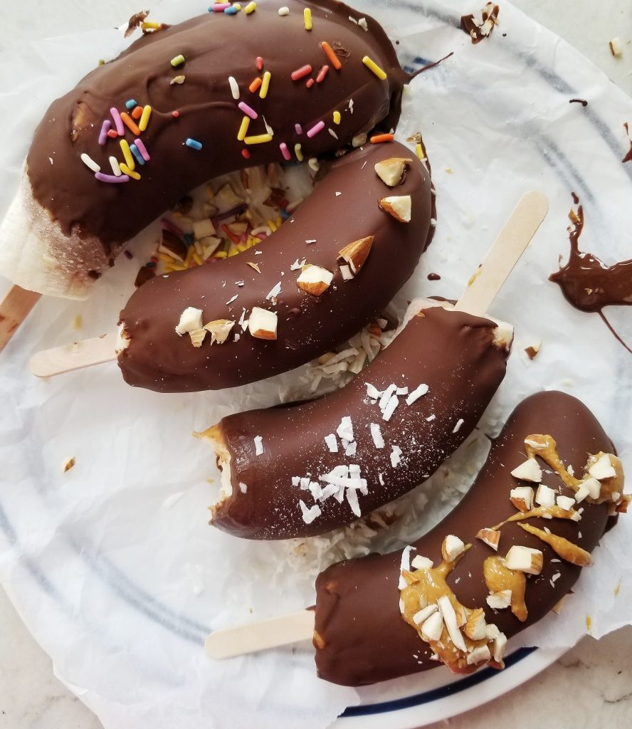 frozen chocolate covered bananas with peanut butter on a plate