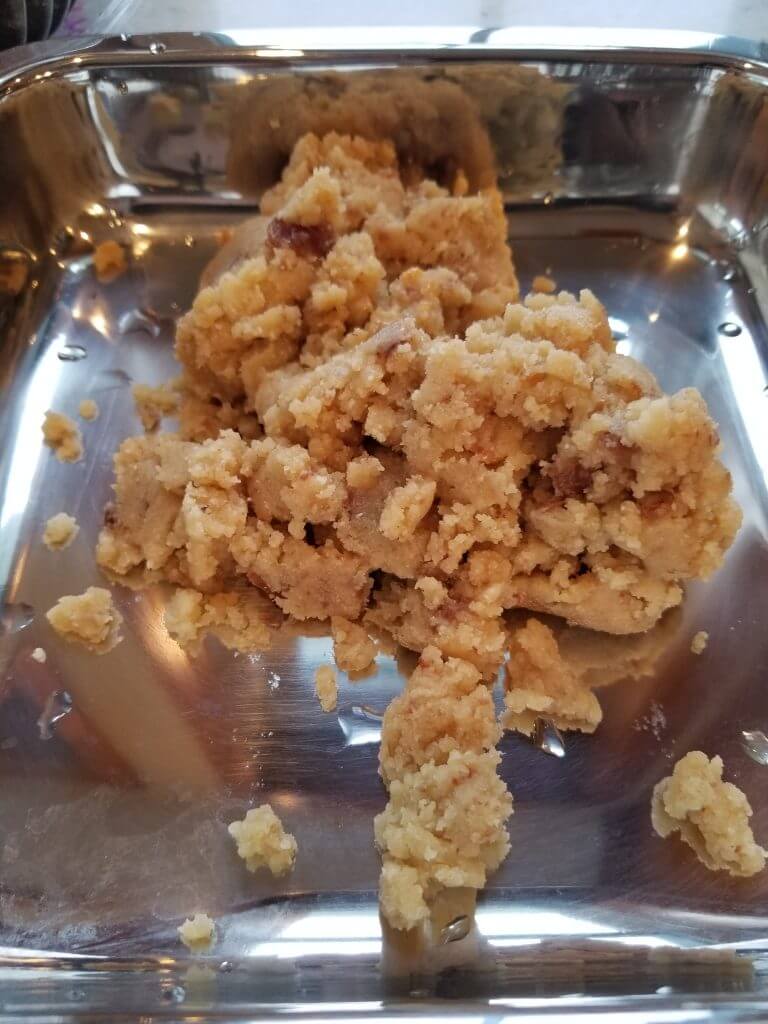 pressing the cookie base of the Twix bars onto the bottom of the pan