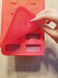 filled popsicle mold with rainbow popsicles