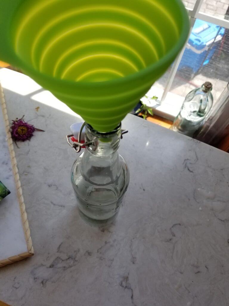 funnel on top of a glass milk jug
