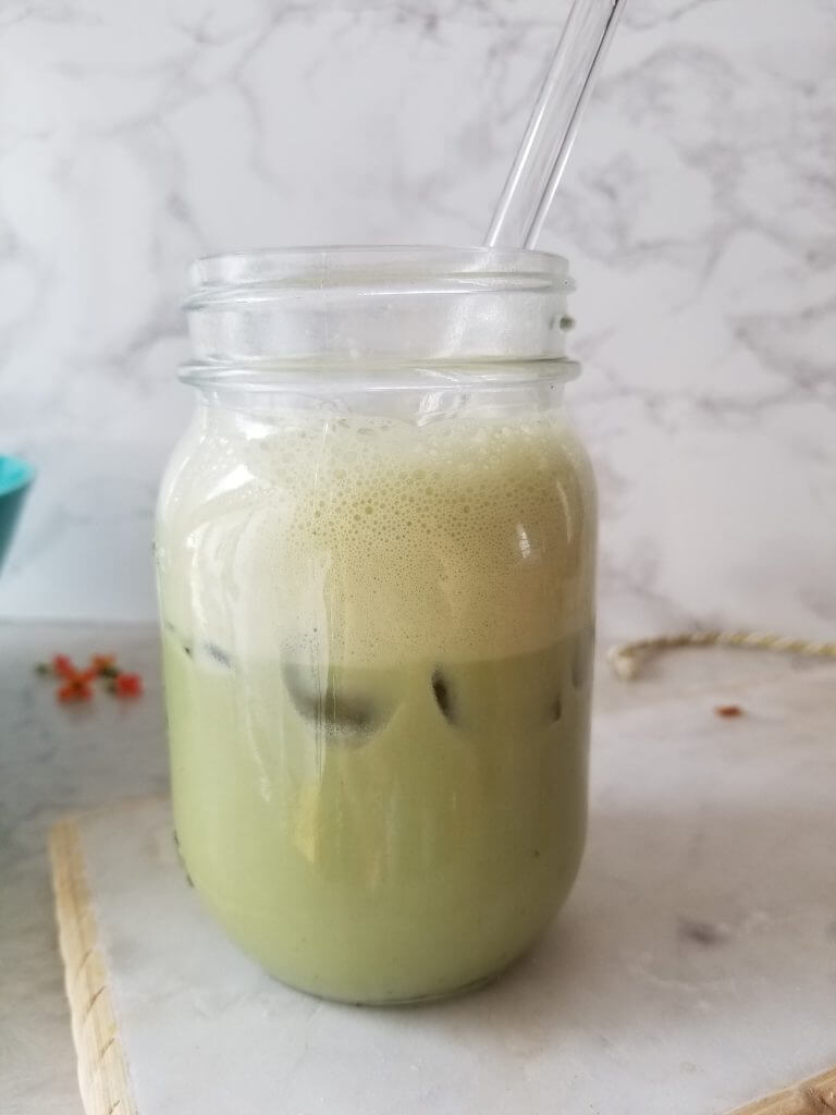 iced matcha in a mason jar with a glass straw