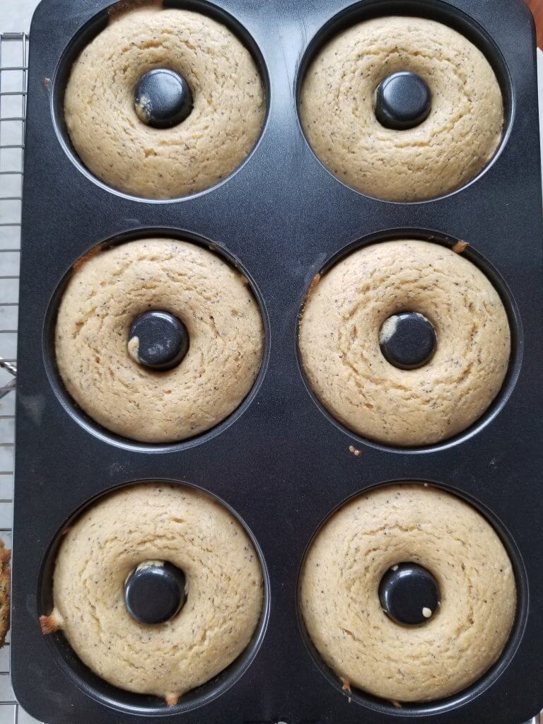 lemon poppy seed doughnuts in a doughnut pan after baking
