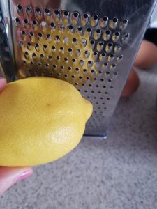 using a cheese grater to zest a lemon