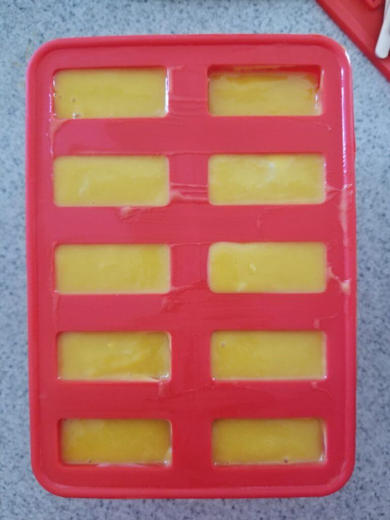 popsicle molds filled with mango puree