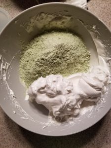 folding almond flour into egg whites for macarons