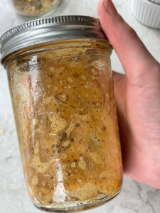 shaking olive oil into espresso in a mason jar with a lid