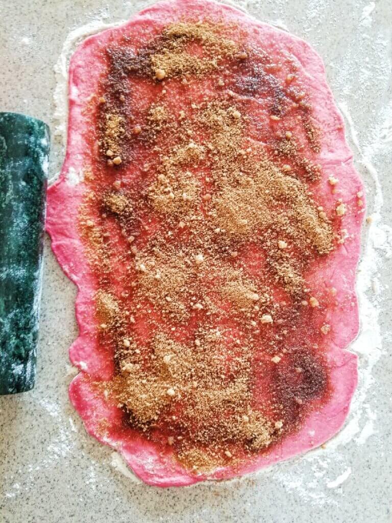 pink cinnamon roll dough with cinnamon filling