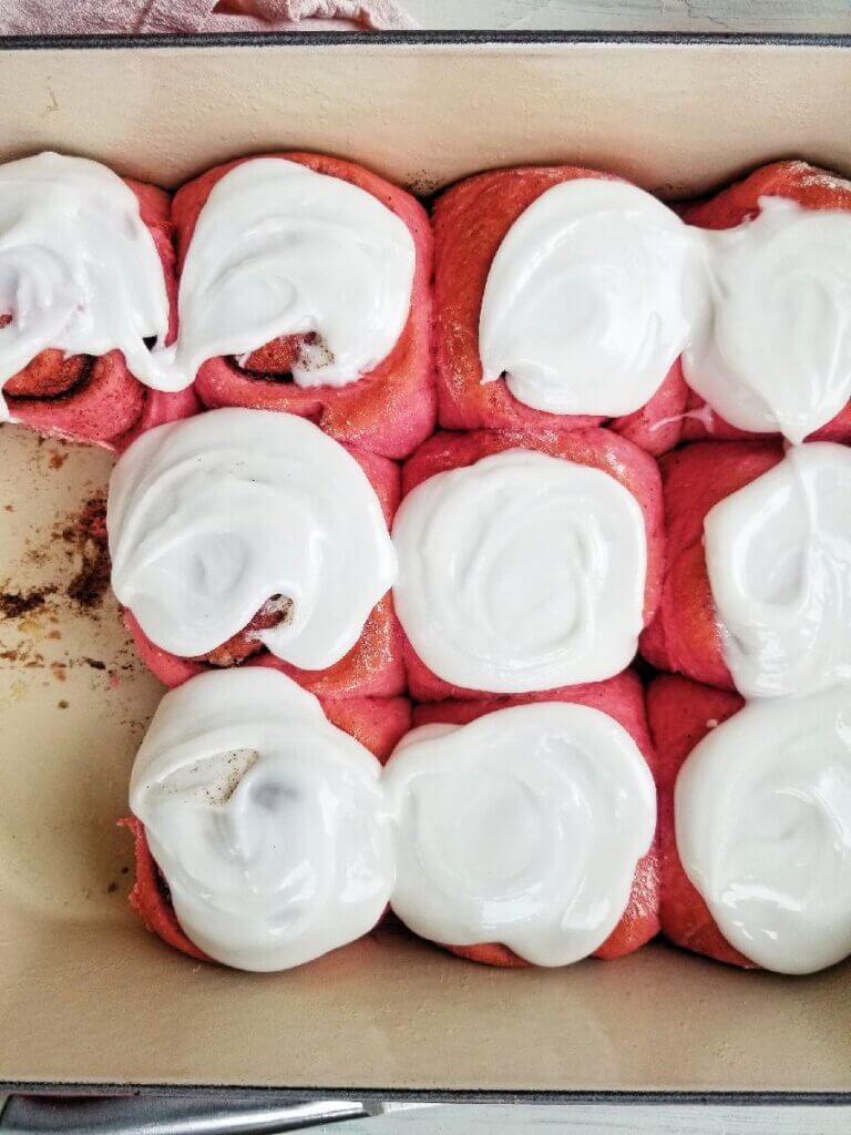 pink cinnamon rolls with vanilla frosting