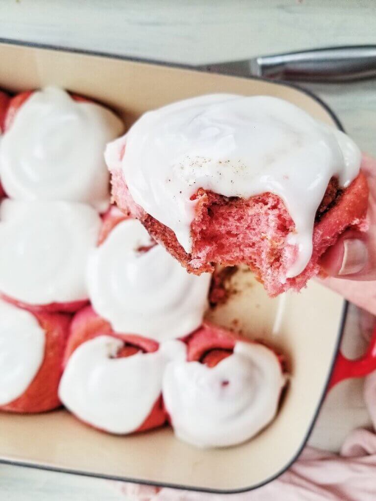 bite shot of a pink cinnamon roll