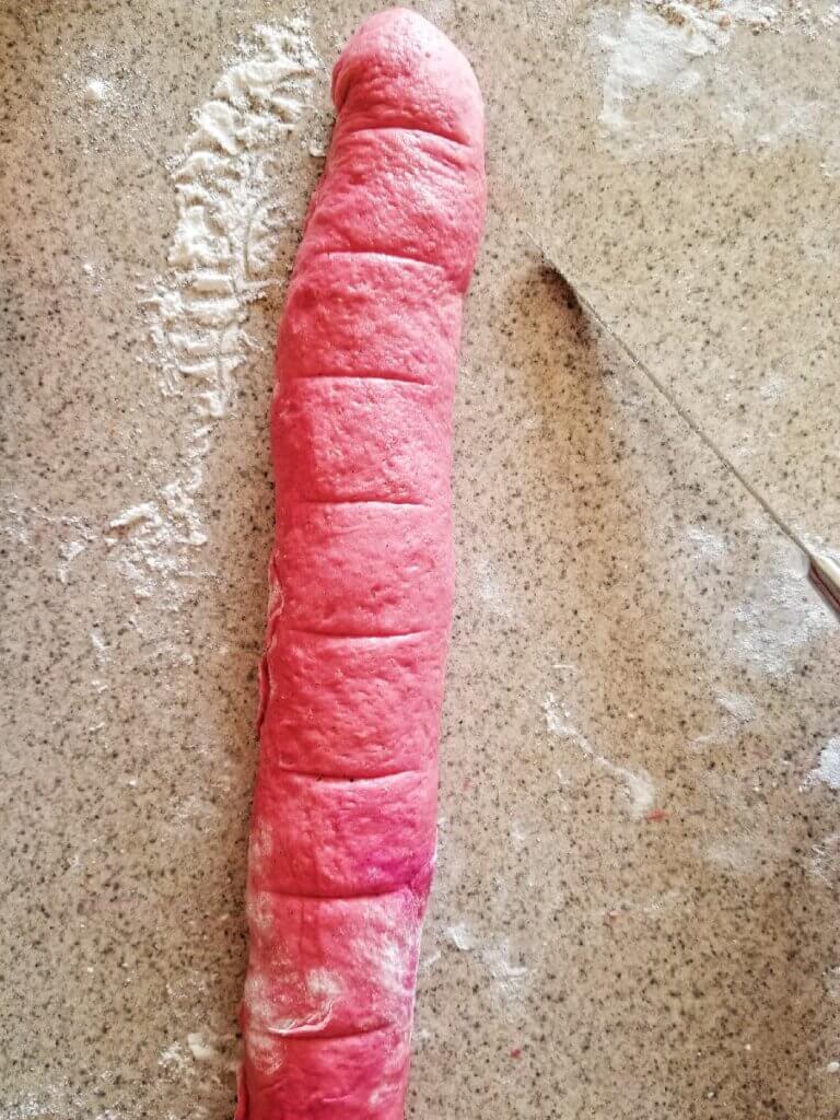 cutting the pink cinnamon rolls to bake