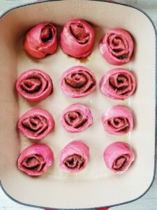 pink cinnamon rolls in pan before rising