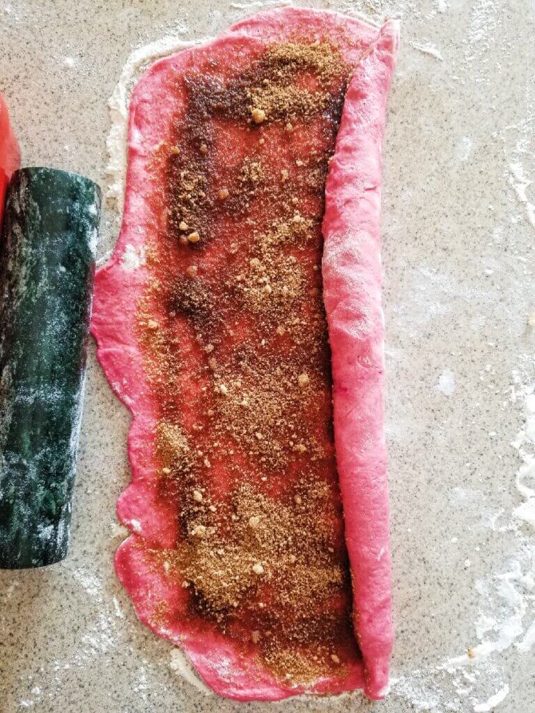 rolling up the pink cinnamon roll dough