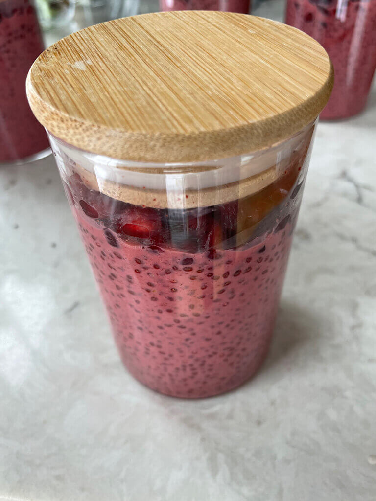 pomegranate chia pudding in a jar with a bamboo lid