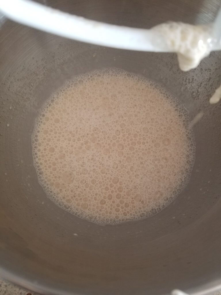 active sourdough starter mixed with water and sugar in a standing mixer