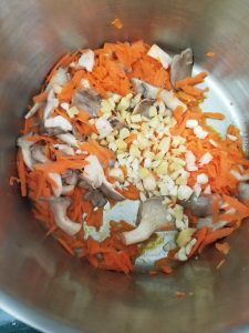 vegetables for the ramen noodle soup in the bottom of a large stainless steel pan