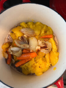 Roasted acorn squash soup ingredients in a Dutch oven