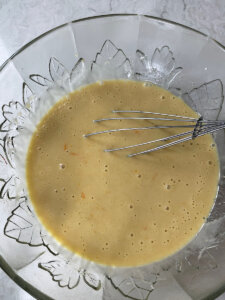 sourdough discard whisked into wet ingredients in a glass bowl