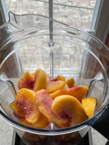 Strawberry peach smoothie bowl in a blender