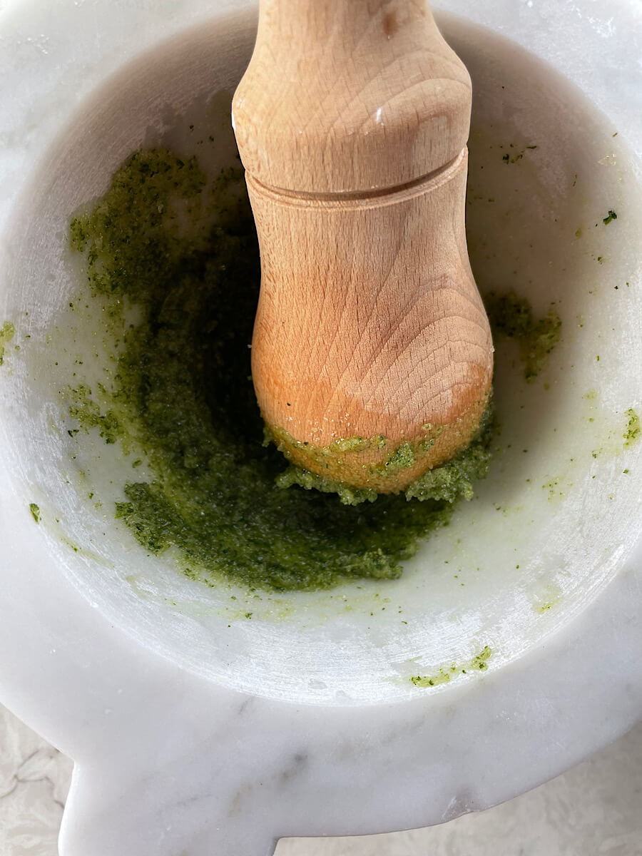 smashing mint leaves with a mortar and pestle