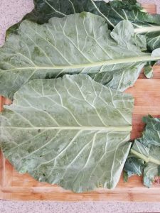 cutting the stems off the collard greens to prepare them for blanching